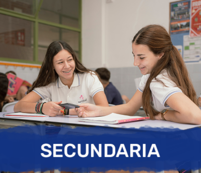 Dos alumnas de Secundaria rien mientras trabajan juntas en clase.