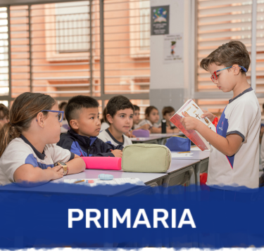 Alumnos de primaria atienden en clase mientras un compañero explica